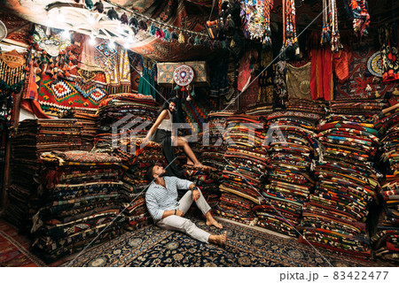 Young couple walking in Cappadocia. Man and woman in the store. Couple in love in Turkey. Man and woman in the Eastern country. Happy couple travels the world. Persian shop. Tourists in store Young couple walking in Cappadocia. Man and woman in the store. Couple in love in Turkey. Man and woman in the Eastern country. Happy couple travels the world. Persian shop. Tourists in store 83422477