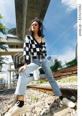 Portrait of 20s Asian Woman brown hair wear jacket high fashion make up under blue sky cloud Portrait of 20s Asian Woman brown hair wear jacket high fashion make up under blue sky cloud 83423082