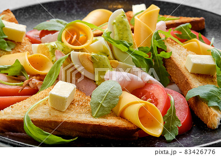 Closeup view of toast, ham, boiled egg, cheddar and tomato 83426776