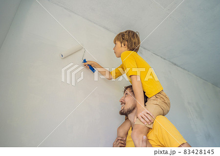 Father and son painting a wall in their home do it in the course of moving in 83428145