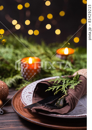 Christmas table setting with decorations, fir branches and candles. 83429215