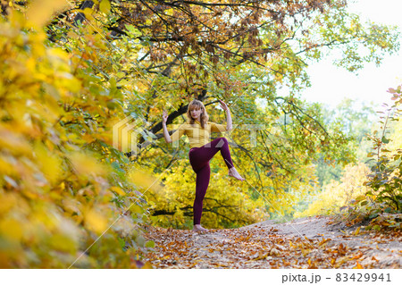 Woman make stretching in autumn scenic forest 83429941