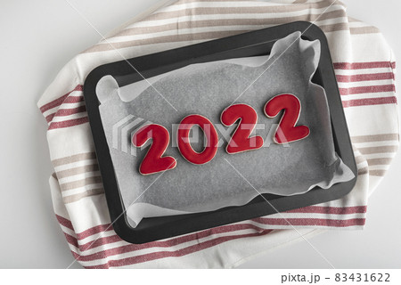 Set of red numbers 2022, ginger cookies on baking sheet. Traditional Christmas gingerbread 83431622