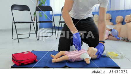 CPR training medical procedure. Demonstration of breast compression on CPR baby doll in class. Medical courses. CPR training medical procedure. Demonstration of breast compression on CPR baby doll in class. Medical courses. 83432571