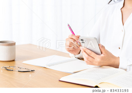 スマホを使って勉強する若い女性【パーツカット】 スマホを使って勉強する若い女性【パーツカット】 83433193