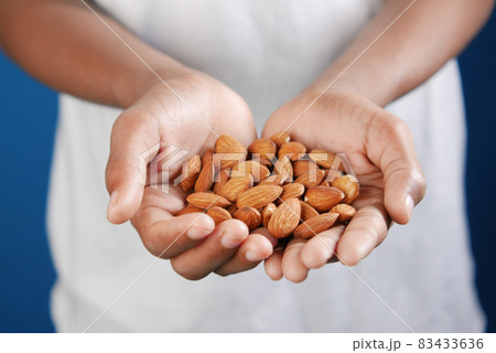 close up of almond nuts on man's hand  83433636