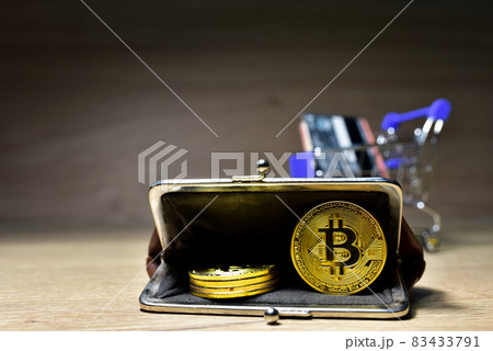 Bitcoins in the wallet. Gold crypto coins in a retro wallet with a shopping basket  83433791
