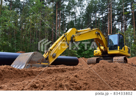 Excavator during earthwork for laying Crude oil and Natural gas pipeline in forest area. Excavator during earthwork for laying Crude oil and Natural gas pipeline in forest area. 83433802