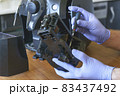 A repairman repairs a broken coffee maker 83437492