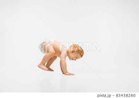 Full-length portrait of little boy, child in diaper standing up isolated over white background 83438260