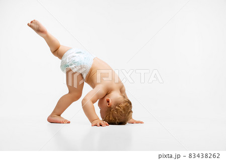 Full-length portrait of cute little boy, playful child in diaper isolated over white background Full-length portrait of cute little boy, playful child in diaper isolated over white background 83438262