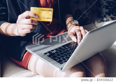 Close up of business woman holding credit card during using laptop for online shopping. Online shopping is the process of buying goods and services from merchants over the Internet. 83438822