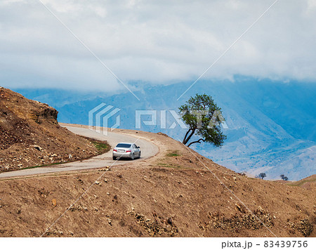 Mountain serpentine road loop. Morning mountain valley with a serpentine road. Silver car on a mountain serpentine. Mountain serpentine road loop. Morning mountain valley with a serpentine road. Silver car on a mountain serpentine. 83439756
