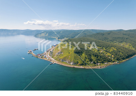 Lake Baikal is a marvelous blue jewel framed by scenic mountains and forests. Epic cinematic aerial view Lake Baikal. Aerial view of blue lake and green forests. Lake Baikal is a marvelous blue jewel framed by scenic mountains and forests. Epic cinematic aerial view Lake Baikal. Aerial view of blue lake and green forests. 83440910