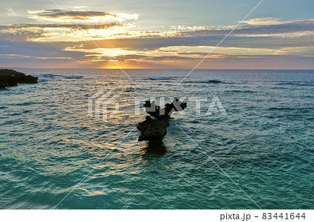 夕陽に染まる沖縄本島の古宇利島のハートロック(ティーヌ浜) 83441644