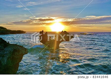 夕陽に染まる沖縄本島の古宇利島のハートロック(ティーヌ浜) 83441646