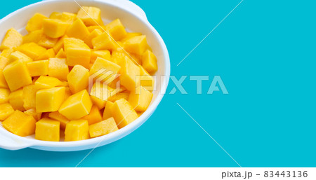 Tropical fruit, Mango cube slices in white bowl on blue background. 83443136