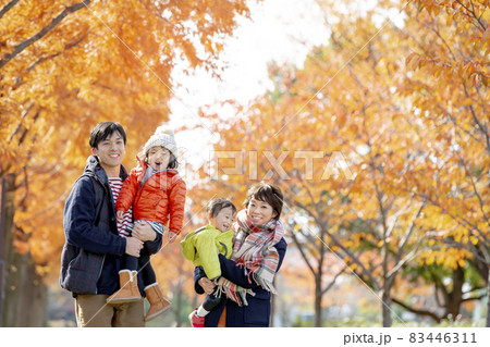 秋の公園を歩く4人家族 83446311