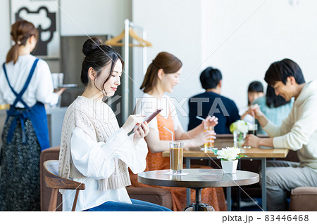 カフェでスマホを見る若い女性 83446468