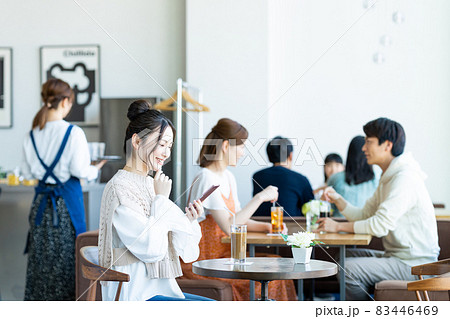 カフェでスマホを見る若い女性 83446469