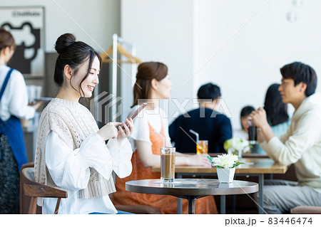 カフェでスマホを見る若い女性 83446474
