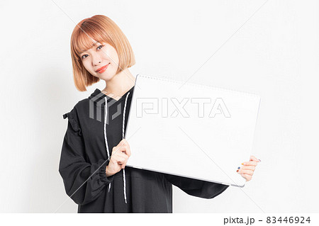 大きいスケッチブックを持っている若い女性 83446924