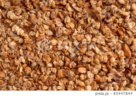Organic granola with oats, raisins, nuts. Texture of brown muesli flakes as background. Top view. Blank space for text. A backdrop of vegetarian and vegan food for breakfast. Healthy nutrition concept Organic granola with oats, raisins, nuts. Texture of brown muesli flakes as background. Top view. Blank space for text. A backdrop of vegetarian and vegan food for breakfast. Healthy nutrition concept 83447844
