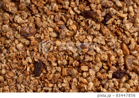 Organic granola with oats, raisins, nuts. Texture of muesli flakes as background. Top view. Blank space for text. Backplate for healthy nutrition concept. Vegetarian and vegan food for breakfast 83447856