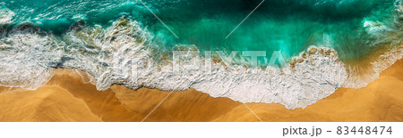 Beautiful sea wave at sunset from a bird's eye view. Beautiful lonely beach at sunset. Aerial view of turquoise ocean waves in Kelingking beach, Nusa penida Island in Bali, Indonesia. Beaches of Bali 83448474