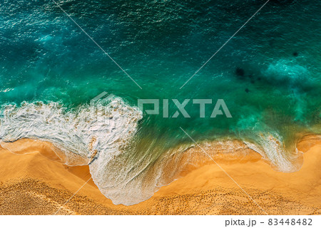 Seascape top view. Panoramic view of the sea waves. Foamy waves roll over the seashore. A vivid picture of marine nature. Stormy oceanic tide. Beaches of Indonesia. Sea foam. Copy space Seascape top view. Panoramic view of the sea waves. Foamy waves roll over the seashore. A vivid picture of marine nature. Stormy oceanic tide. Beaches of Indonesia. Sea foam. Copy space 83448482