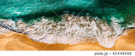 Beautiful sea wave at sunset from a bird's eye view. Beautiful lonely beach at sunset. Aerial view of turquoise ocean waves in Kelingking beach, Nusa penida Island in Bali, Indonesia. Beaches of Bali 83448488