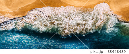 Aerial view of blue ocean waves in Kelingking beach, Nusa Penida island in Indonesia. Beautiful sandy beach with blue sea. Lonely sandy beach with beautiful waves. Beaches of Indonesia. Copy space 83448489