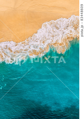 Beautiful sandy beach with turquoise sea, vertical view. Drone view of tropical turquoise ocean beach Nusa penida Bali Indonesia. Lonely sandy beach with beautiful waves. Beaches of Indonesia. 83448609