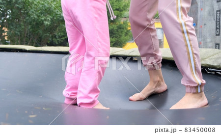 young woman and a young girl are jumping on a ram, close-up. Legs float in the air after jumping on young woman and a young girl are jumping on a ram, close-up. Legs float in the air after jumping on 83450008