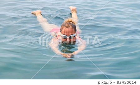 woman aged 50-55-60 years old swims in the sea by a crawl. Professional swimmer, swimming race 83450014