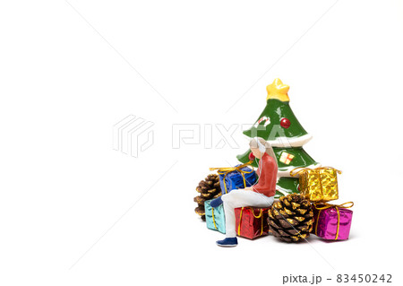 Miniature people , Woman wearing headphones sitting on gift box 83450242