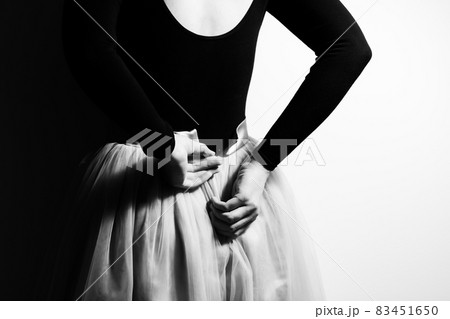 The ballerina prepares for the performance, fastens the ballet tutu. Black and white photo. Photo from the back. The ballerina prepares for the performance, fastens the ballet tutu. Black and white photo. Photo from the back. 83451650