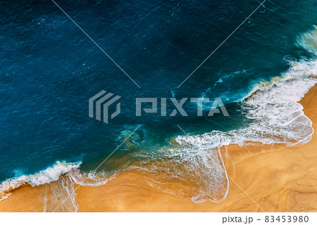 Aerial top view from drone of sandy beach with blue sea waves with copy space for text. Summer sea beach top view. Panoramic view of the sea with sandy beach. Seascape, can be used as a background Aerial top view from drone of sandy beach with blue sea waves with copy space for text. Summer sea beach top view. Panoramic view of the sea with sandy beach. Seascape, can be used as a background 83453980