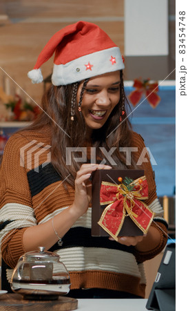 Smiling woman using video call technology for presents Smiling woman using video call technology for presents 83454748