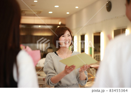 職場の異動でプレゼントを受け取る女性 83455364
