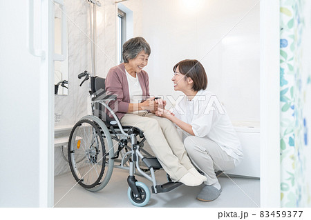 お風呂場で車椅子に乗る老婆と介護する孫 お風呂場で車椅子に乗る老婆と介護する孫 83459377