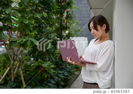 オフィスでノートパソコンを持ちながら仕事をする日本人女性 オフィスでノートパソコンを持ちながら仕事をする日本人女性 83463387
