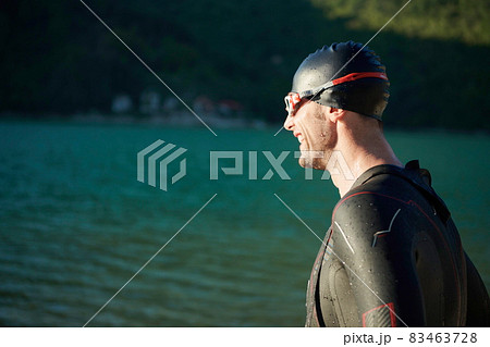 triathlon athlete starting swimming training on lake 83463728