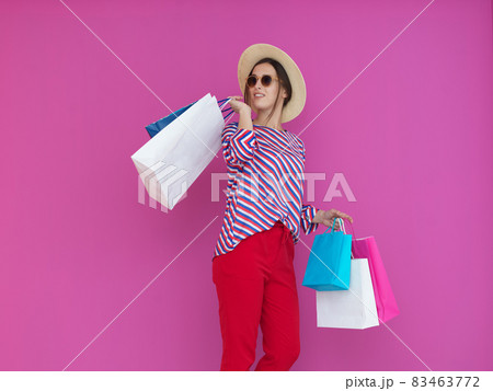 Young woman with shopping bags on pink background Young woman with shopping bags on pink background 83463772