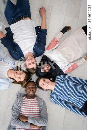 top view of a diverse group of people lying on the floor and symbolizing togetherness top view of a diverse group of people lying on the floor and symbolizing togetherness 83464133