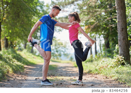 couple enjoying in a healthy lifestyle warming up and stretching before jogging couple enjoying in a healthy lifestyle warming up and stretching before jogging 83464256