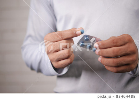 young man hand holding blister packs taking medicine young man hand holding blister packs taking medicine 83464488