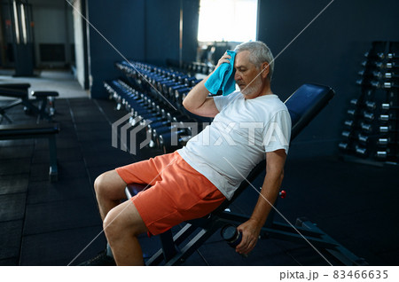 Tired old man with towel leisures after workout Tired old man with towel leisures after workout 83466635