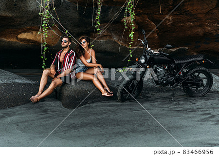 A couple in love on the beach meets the sunset. Beautiful couple on a bike. Lovers on the beach. A man and a woman on the beach. Stylish couple on a motorbike. Copy space A couple in love on the beach meets the sunset. Beautiful couple on a bike. Lovers on the beach. A man and a woman on the beach. Stylish couple on a motorbike. Copy space 83466956