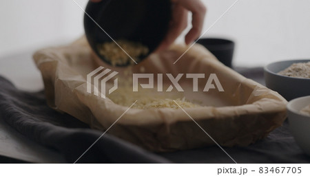 man making granola at home, pour oats on baking paper 83467705